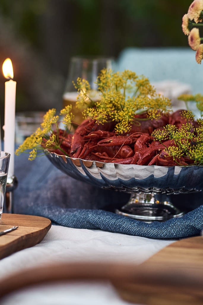 Kräftskiva - dukning & detaljer. Här Bernadotte serveringsskål i krom med kräftor i på ett dukat middagsbord.