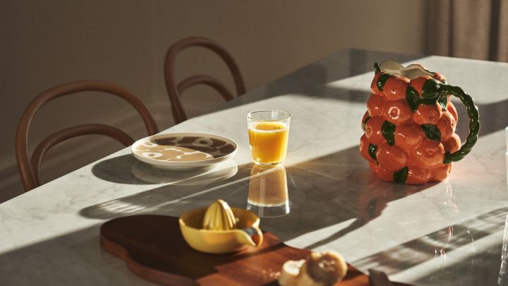 Dukat bord med Marimekko-porslin, juice och karaff från BYON i utförandet av mandariner. 