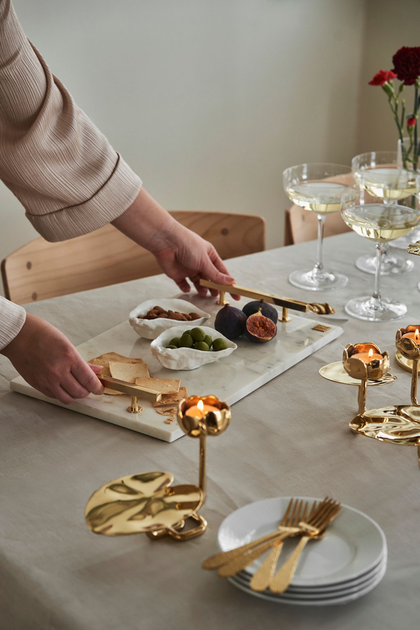 Bjud dina vänner på afternoon tea på Galentine's Day. Här ser du en marmor tråg från Hilke Collection tillsammans med några ljusstakar i guld i form av en näckros.