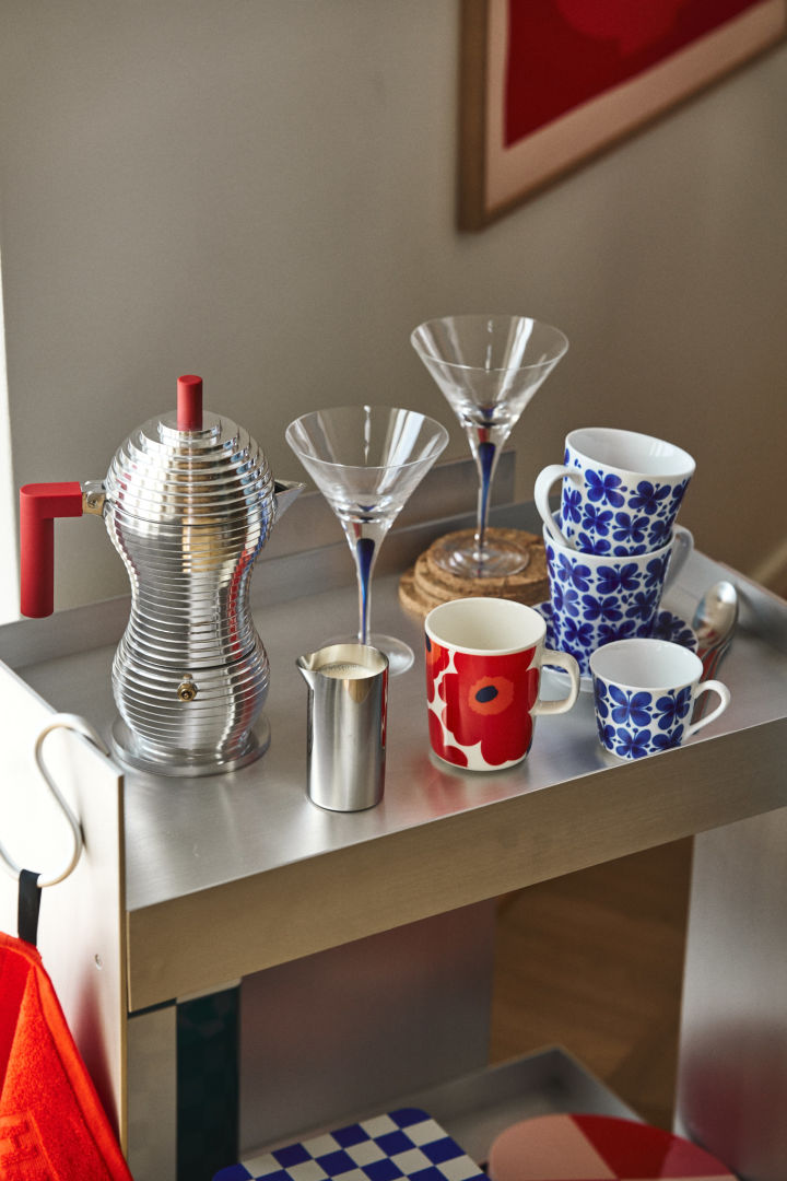 Här ser du en retro-inspirerad kaffe-station i krom med muggar i rött och blått tillsammans med cocktailglas i blått, nostalgisk inredning är en av de stora trenderna enligt höstens inredningstrender 2024.