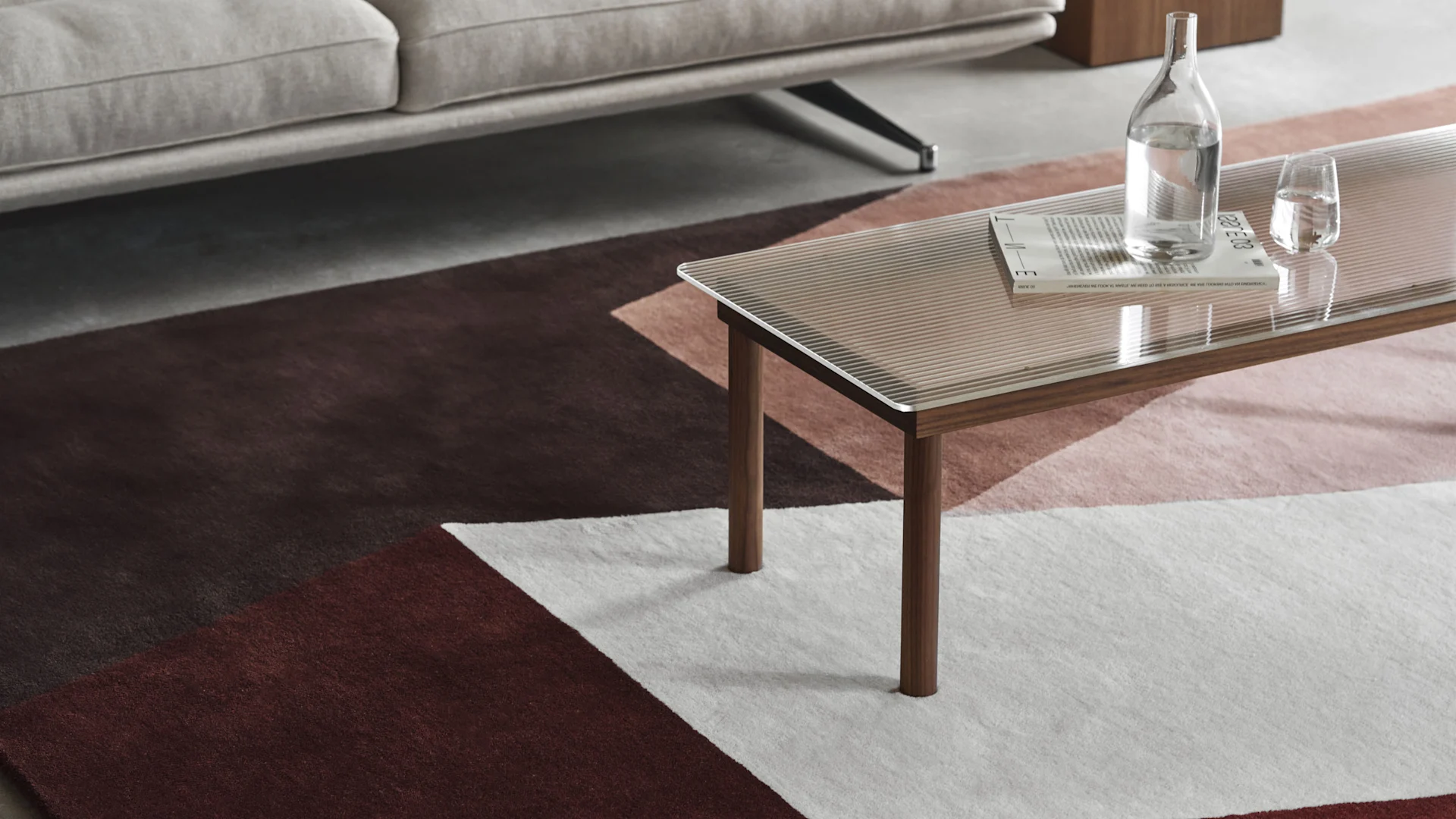 Modernt vardagsrum med en geometriskt mönstrad matta, soffbord i glas och en 'WEEKEND DEAL'-överlagring.