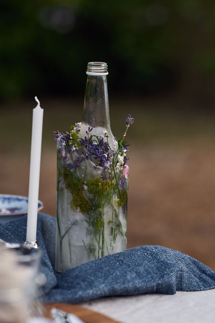 DIY-tips till kräftskivan - frys ned en flaska med vatten i ett hölje av blommor. 