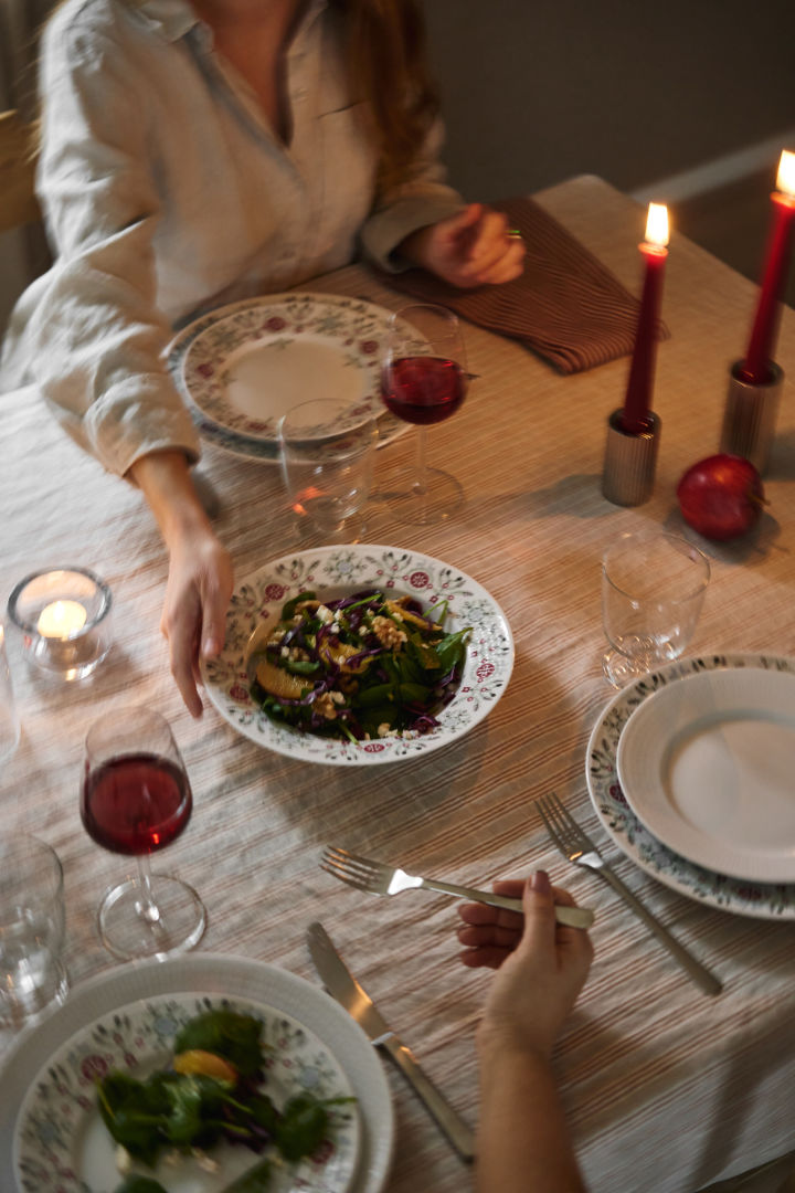 En hand skickar en vintersallad över bordet som en del av en skandinavisk juldukning. 